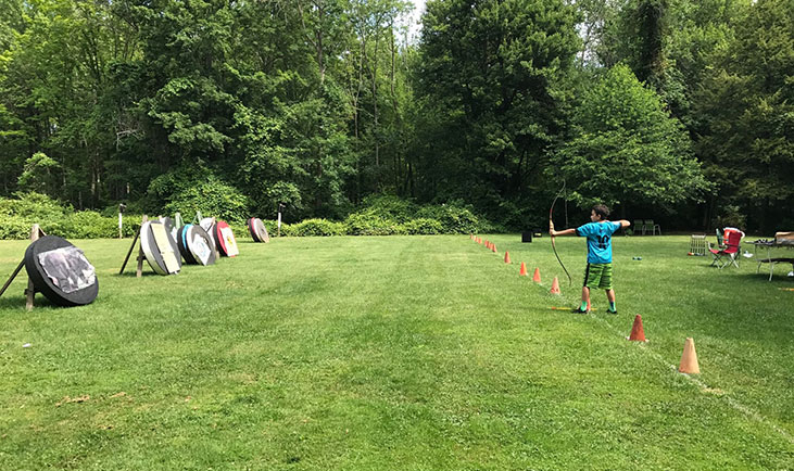 one boy shooting arrow at archery course