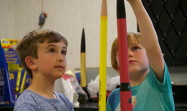 Boys looking at giant pencils