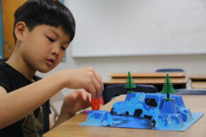 Camper playing with LEGOs at Renbrook Summer