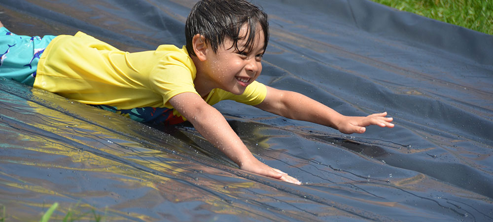 Camper on the waterslide at Pre-Season Camp