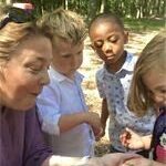 Julie Schlossinger excitedly looking at critter with students