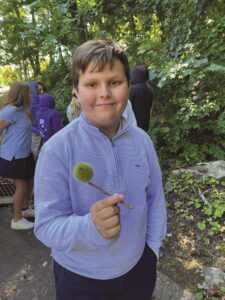 male student holding an American Chestnut burr