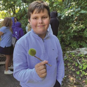 male student holding an American Chestnut burr