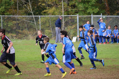 Soccer - Boys Junior Varsity players running up field