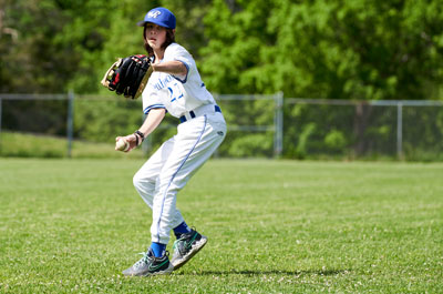 Baseball - Boys Varsity player winding up to throw ball