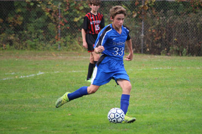 Soccer - Boys Varsity player intensely managing ball