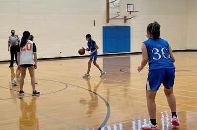 Basketball - Girls Junior Varsity player dribbling down court