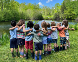 friends with arms around each other at pond