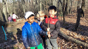 Kindergarten students playing in woods