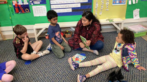 Kindergarten parent reading to students.