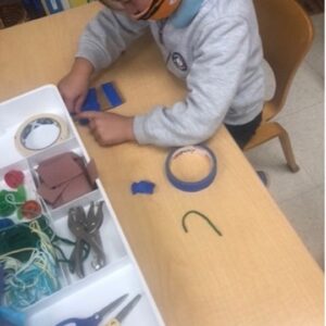 child in mask working on project