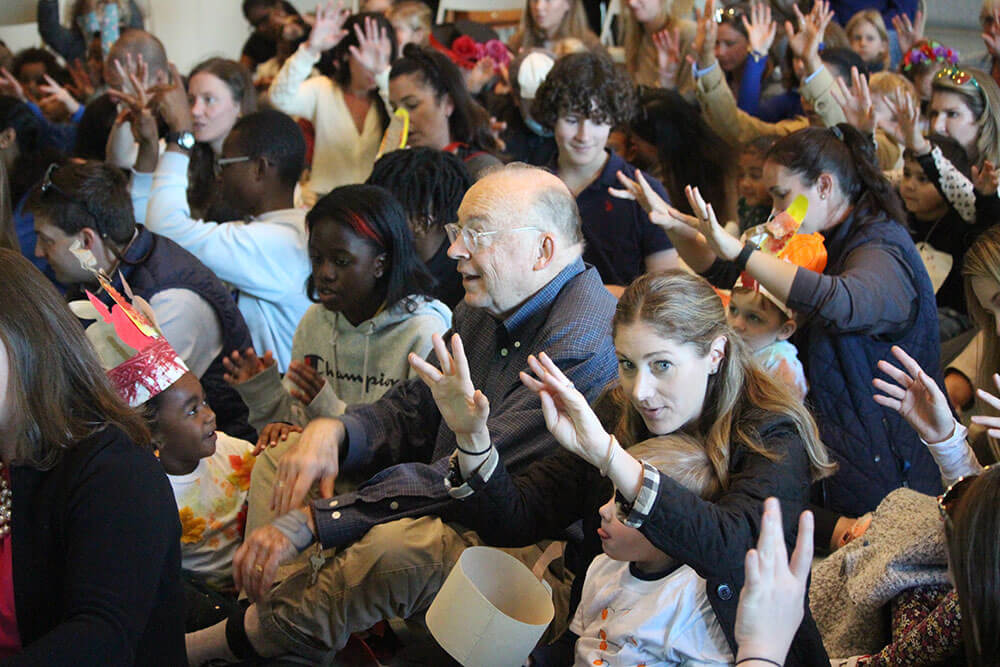 group of students, parents, and grandparents singing together as a community