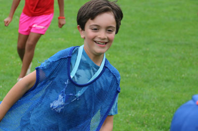 boy running in field smiling