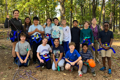 group pf middle school students with PE teacher at challenge course