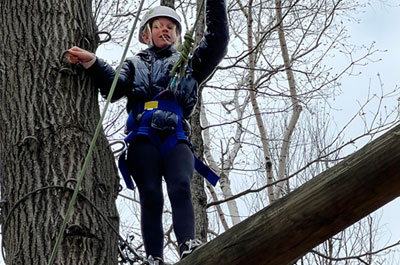 girl on high ropes element on cloudy day