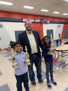 chess students and teacher with their trophies