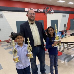 chess students and teacher with their trophies