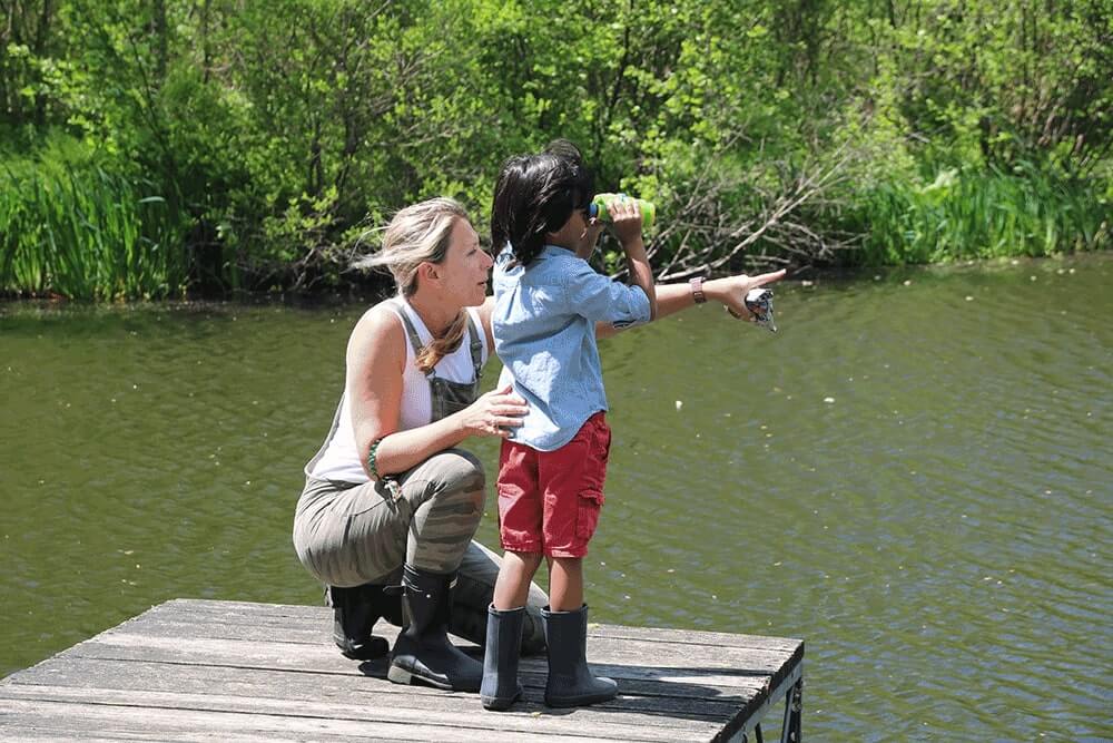 Teacher on Dock Pointing with a student using binoculars