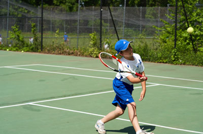 junior varsity tennis player tapping ball