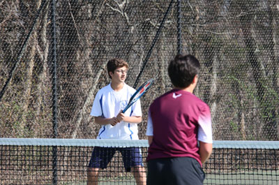 two upper school boys on tennis court ready to play