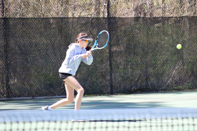 girl playing tennis with visor on