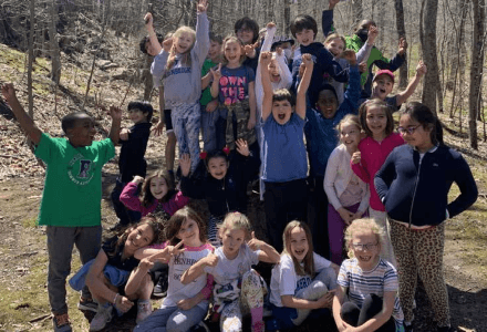 group of children in woods cheering