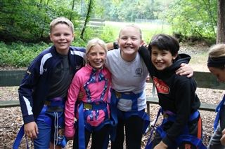 students in harnesses at ropes course