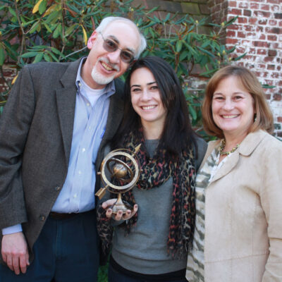 Distinguished alumnus posing with family and holding award