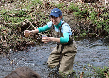 Science teacher releasing salmon into river