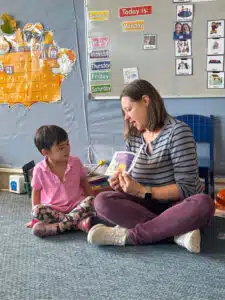 Preschool teacher reading to an Asian girl