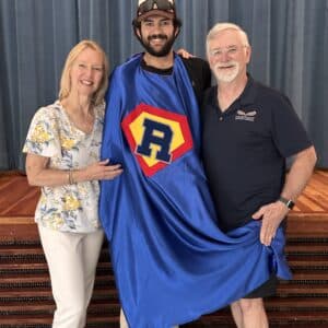 Aidan Guzman receiving award and superhero cape