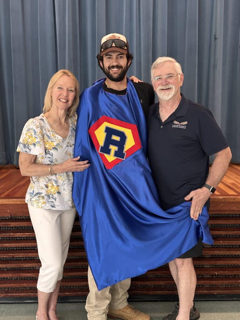 Aidan Guzman receiving award and superhero cape