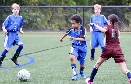 3 Renbrook boys playing soccer with 1 girl from opposing team present