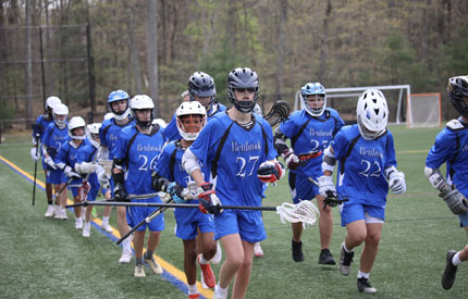 varsity boys lacrosse players warming up with a run