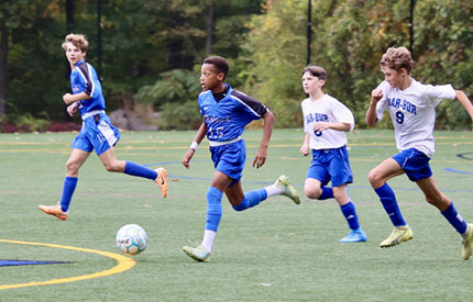 4 male soccer players with soccer ball