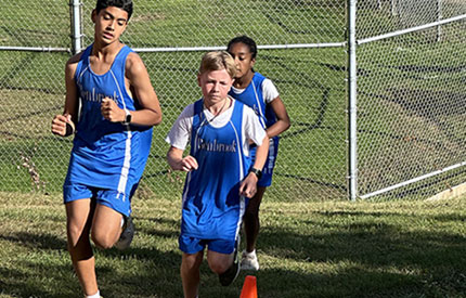 3 middle school boy running up a hill