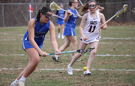female lacrosse players going after ball