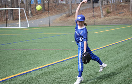 middle school girl pitching a softball in a game