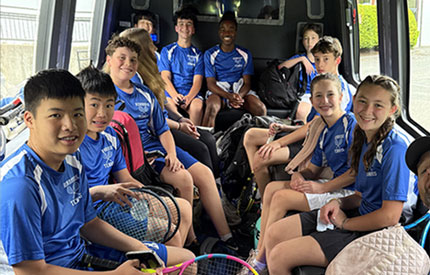 group of middle school tennis players on a bus headed to a game