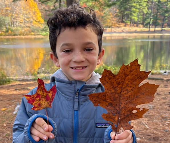Third grade boy holding two leaves
