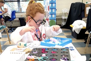 Girl Pretending to be a doctor at summer camp