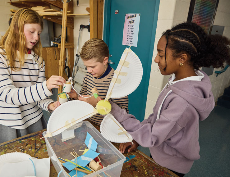 three students creating a windmill