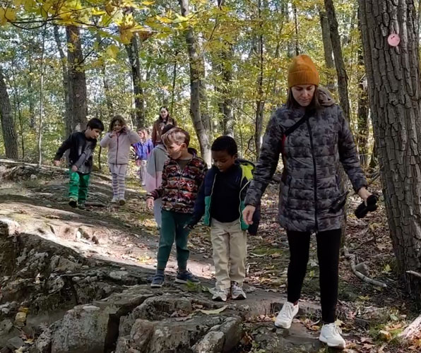 kindergarten students hiking through the woods