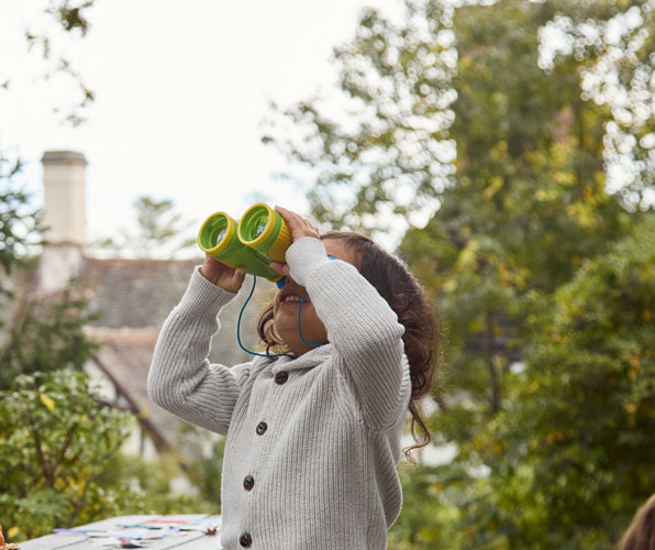 young male student looking through binoculars