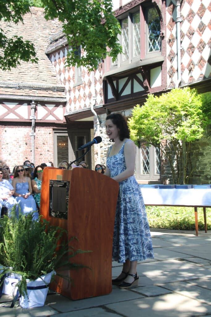 woman standing at lecturn delivering a graduation speech