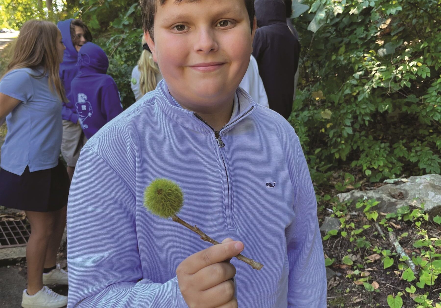 male student holding an American Chestnut burr