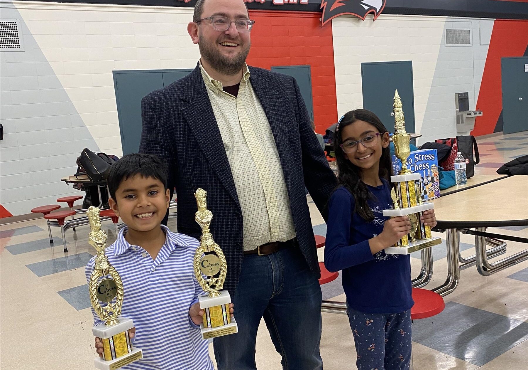 RenbrookChessTeamWinsFifth chess students and teacher with their trophies